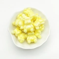 Macro shot of yellow pearlescent bear beads in a white petal dish for DIY jewelry - Yellow