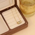 Makroaufnahme der goldenen Edelstahlkette mit einem blau-weißen Evil Eye Anhänger - Blau