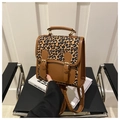 Detail of a brown leopard print backpack with faux leather straps and vintage gold buckles - Brown