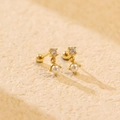 Elegante goldene Perlenohrstecker mit funkelnden Zirkonia auf einer Steinfläche - 925er Silber / Gold