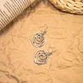 Detailed close-up of silver vintage spiral earrings on a decorative paper background - Antique Silver Spiral Floral
