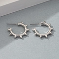 Detail view of silver punk hoop earrings with spike charms on a minimalist grey background - White Gold