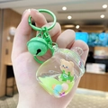 Porte-clés ours dans un biberon vert avec paillettes liquides et clochette - Ours à Salopette Biberon / Vert