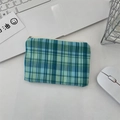 Detailed top view of a blue plaid zipper pouch on a white desk with office accessories - Diagonal Blue-Green Grid