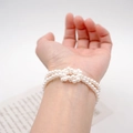 Elegante bracciale a due fili di perle con un design a nodo minimalista sul polso - Bracciale / Bianco