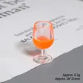 Close-up of a 38x21mm miniature red wine glass model with orange liquid and 6.5g weight - Orange