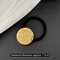 Minimalistischer goldener Haargummi mit Hammerschlag-Struktur und elastischem Band - Goldrunde Lavatextur