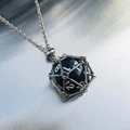 Collier en argent avec un pendentif dé noir à 20 faces dans une cage métallique - Cage d'argent avec dé noir