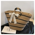 Detail of hand-woven straw tote bag with black stripes and white lace bow decoration - One Size / Khaki