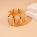 Détail d'un bracelet extensible avec pièces en résine pêche et losanges en métal doré - Café Clair