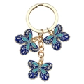 Golden keychain featuring three teal enamel butterfly charms on a white background - Blue Butterfly (ER714)