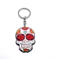 Detail of Day of the Dead sugar skull keychain with floral patterns and acrylic finish - Style F