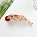 Detail view of a resin flower banana clip with sparkling rhinestones and a curved design - Champagne Gold