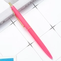 Stylo à bille rétractable rose avec clip doré sur un bureau de style minimaliste - Pointe Balle 1,0 mm / Rose vif