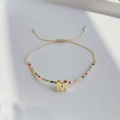 Detailansicht eines bunten Boho-Perlenarmbands mit goldenem M-Buchstaben und verstellbarer Kordel - Buchstabe M