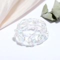 Detail showing the iridescent reflection of this acrylic chain ring on silk fabric - Clear Iridescent