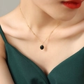 Collier élégant à chaîne dorée avec pendentif pierre noire ovale sur un mannequin - Petit pendentif noir / Doré