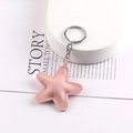 Dettaglio macro di un portachiavi a stella in pelle PU rosa con anello e catenina - Rosa