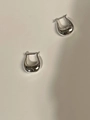Close-up of minimalist silver tulip U-shaped stud earrings in a polished metallic finish - Silver