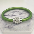 Dettaglio macro del bracciale in silicone verde con chiusura magnetica in argento e cristalli - verde chiaro
