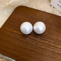 Detailopname van pareloorbellen met zijden textuur op een houten presentatie - Zilveren Naald-Wit-20mm