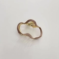 Detail of a wavy metal hair claw clip with gold frame and premium morandi enamel finish - Brown
