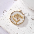 Detailed view of handmade daisy resin pendant with gold foil on a white textured stone - White Flower Bouquet With White Leaves And Gold Foil