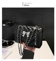 Detail of black quilted shoulder bag featuring silver metal bow and leather chain strap - Black