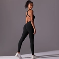 Detail van een zwarte naadloze yoga jumpsuit met een open rug en racerback bandjes - S / Zwart
