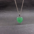 Macro shot of a green heart-shaped crystal stone pendant with a silver necklace chain - Green Aventurine with Chain