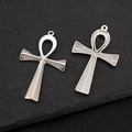 Dettaglio di ciondoli a croce Ankh in argento con texture lisce e sbalzate su pietra - Croce testurizzata 3D
