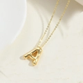 Macro detail of 14K gold plated necklace showing 3D puffy balloon letter A pendant - Letter A