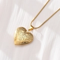 Golden heart-shaped relief locket necklace for couples on a textured white background - Scroll Vine Relief