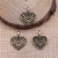 Three vintage heart filigree pendants on rustic wood for handmade jewelry crafts - Antique Bronze