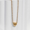 Gedetailleerde weergave van gouden hartvormige hanger met gotisch getal 888 aan een ketting - 888