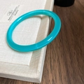 Close-up of translucent green resin bangle with glossy finish on a minimalist display - 63# Bracelet-Cyan Blue Glossy