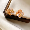 Macro shot of clover pearl earrings with orange zircons on a leather jewelry box - Flower Stud Style (925 Sterling Silver Earring Post)