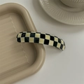 Detailed close-up of a checkered acetate hair clip with a smooth high-gloss finish - Checkered