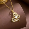 Golden butterfly necklace with pearl and sparkling zircon stones on a brown display - Butterfly Pearl Style