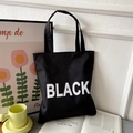 Versatile black canvas tote bag with bold white BLACK lettering for a stylish look - Black with BLACK Text