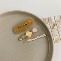 Detailed view of 3-piece pearl and gemstone hair clips set on a decorative plate - Style 9 (3-Piece Set/Gold Glitter Geometric)