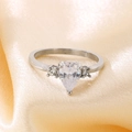 Detailopname van een peervormige zirkoon ring op een elegante perzikkleurige zijden stof - US 6 / Staal met heldere hoofdsteen (KR111192-TOM)