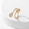 Detailed macro view of golden double-teardrop open ring with pavé-set cubic zirconia - Style 7 / Gold