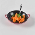 Gros plan d'une mini poêle rouge avec crevettes et spatule pour maison de poupée - Crevette