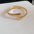 Macro detail of golden open cuff bracelet featuring polished water drop leaf ends - Waterdrop Style (Gold)