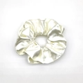 Macro detail of creamy white satin scrunchie with soft silk texture and elegant folds - Off White