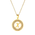 Detail of a gold circular pendant featuring letter X with sparkling zircon stone inlay - Letter X