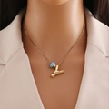 Detail of female model wearing gold Y-shaped alphabet necklace with blue evil eye bead - Gold Letter Y