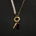 Stainless steel pearl necklace with red gemstone pendant in 14K gold finish. - Gothic Letter T