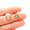 Makroaufnahme goldener Baby-Cartoon-Ohrstecker zur Größenanzeige in der Hand - 736 Engelsbabys / Roségold